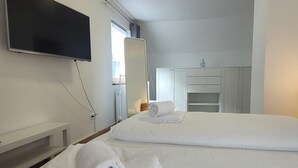 A hotel room with two beds, a flat-screen TV, a mirror, and a wardrobe. - Apartment in Winterberg Near Ski Lift (Winterberg)