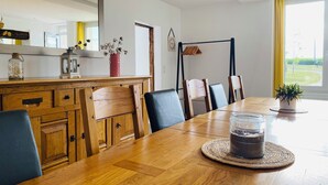 A dining area with a wooden table, chairs, and a central island with a vase and a candle. - ❤️ A unique venue for your most memorable moments - group gîte with sleeping facilities (Nouans)