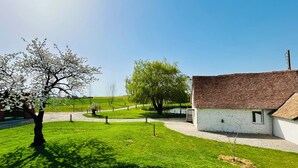 A rural setting with a white building with a tiled roof, surrounded by green grass and trees. - ❤️ A unique venue for your most memorable moments - group gîte with sleeping facilities (Nouans)