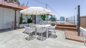A patio with a table and chairs, a white umbrella, and a pool area with lounge chairs. - 'Casa Mica' with Mountain View, Wi-Fi and Air Conditioning (Vega de San Mateo)