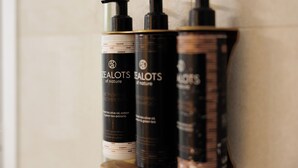 Drei Flaschen 'TEALOTS of nature' Shampoo und Conditioner auf einem Regal.