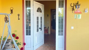A doorway with a white door and glass panels, leading to a tiled hallway. - Rustic Villa with Private Pool near Ocean, Hiking & Cycling Trails – Sleeps 9 (CN)