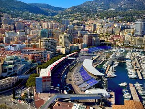 A coastal cityscape with a stadium, marina, and dense urban buildings.