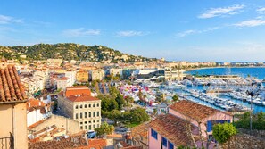 A coastal cityscape with a marina filled with boats, historic buildings, and a hilly backdrop. - Charming 3 rooms located in Le Cannet, near Cannes (Le Cannet)