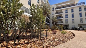 A multi-story building with balconies, surrounded by landscaped areas with trees and mulch. - Charming 3 rooms located in Le Cannet, near Cannes (Le Cannet)