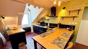 A cozy kitchen with a wooden table, a built-in oven, and a window. - Apartment near the royal square, Nantes (Nantes)