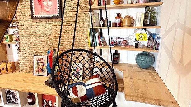 A room with a hanging chair, bookshelves, and a brick wall. - Apartment near the royal square, Nantes (Nantes)