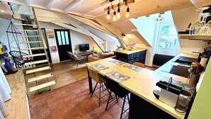 A loft-style kitchen with a dining area, a staircase, and a view of the city. - Apartment near the royal square, Nantes (Nantes)