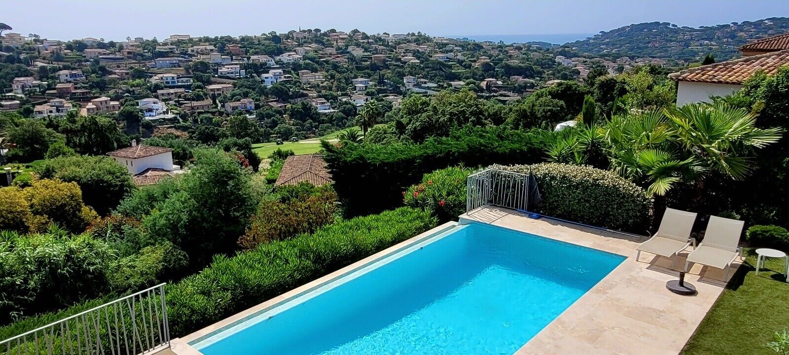 Une piscine avec vue sur une ville située sur une colline.