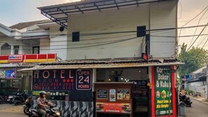 Un hotel con un cartel que indica que está abierto las 24 horas.