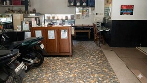 Una habitación con piso de baldosas, una recepción, una motocicleta y un cartel que indica hotel gratuito.