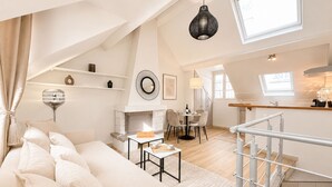 A spacious loft with a high ceiling, a dining area, a kitchen, and a staircase. - 2066 Princesse (Paris)