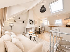 Un loft amplio con techo alto, comedor, cocina y escalera.