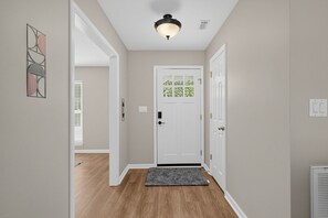 Entryway with wood-style flooring, a white front door, and neutral-toned walls.