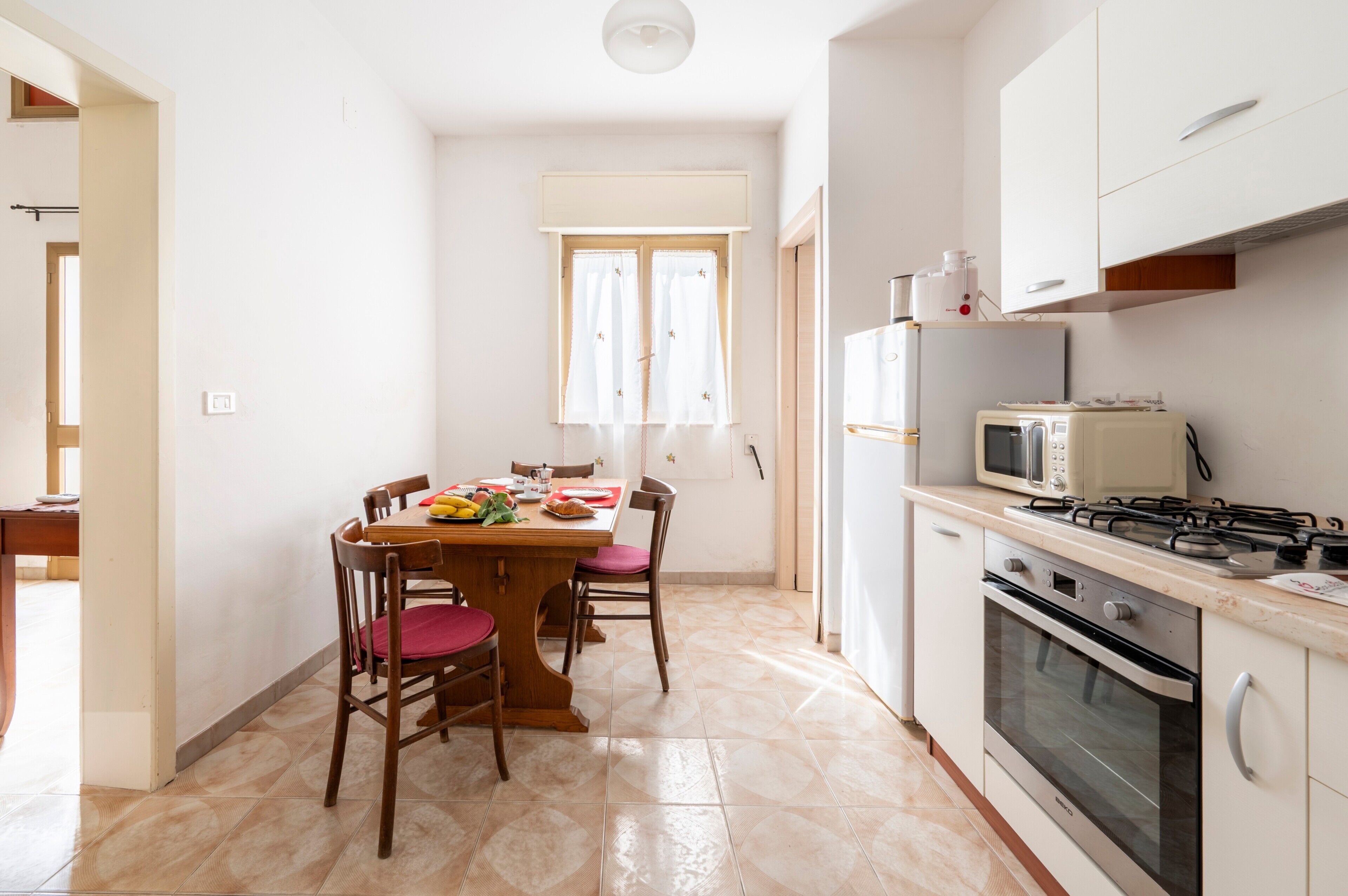 Une cuisine équipée d’une table à manger, de chaises, d’un four à micro-ondes, d’une cuisinière, d’un four et de placards.