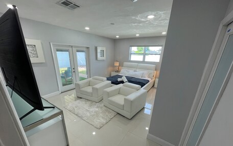 A modern bedroom with a large bed, a sofa, and a TV.