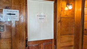 A wooden door with a sign indicating the D-Miles Smith Farm Suite and a private entrance for Suite B.