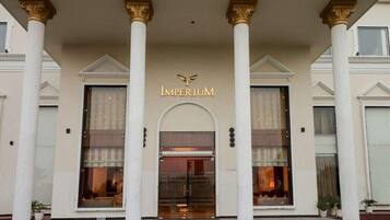 A building with a grand entrance, featuring a sign that reads "IMPERIUM" above the doors.