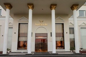 A building with a grand entrance, featuring a sign that reads "IMPERIUM" above the doors.
