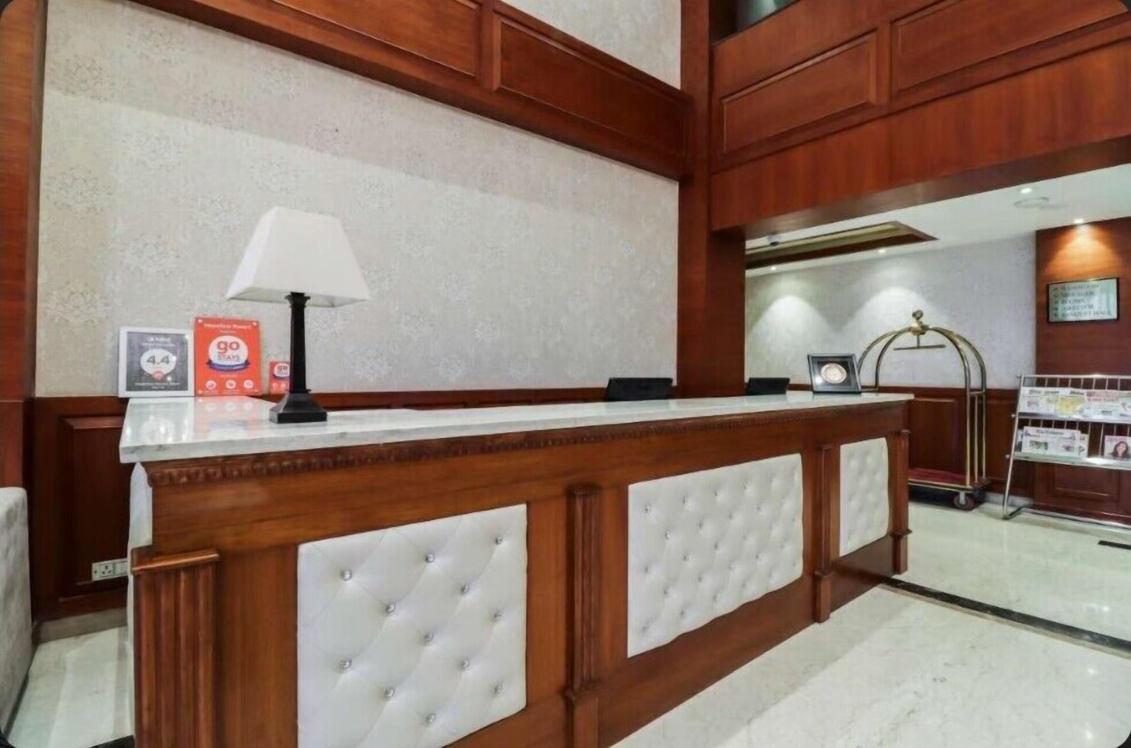 A reception desk with a white lamp, framed certificates, and a sign for a 4.4 rating.