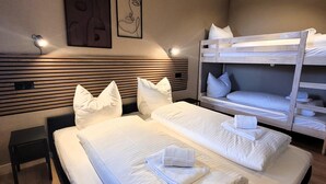 A hotel room with two beds, a wooden headboard, and a small bedside table. - Apartment in Winterberg Near Ski Lift (Winterberg)
