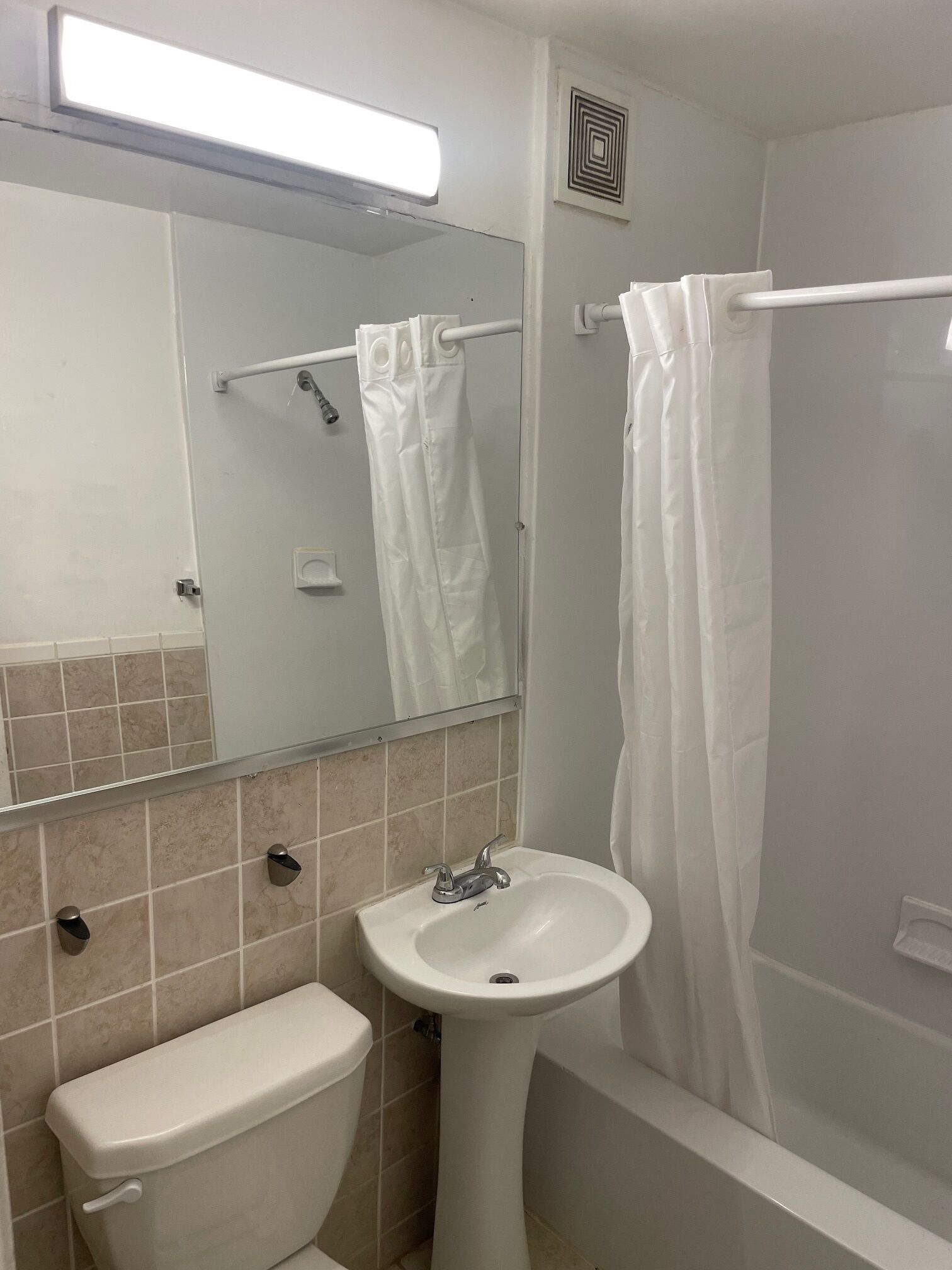 Een badkamer met toilet, wastafel en douche.