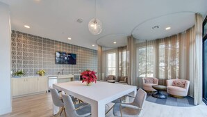 A modern kitchen with a white countertop, grey chairs, and a large dining table. - This studio is a 0 bedroom(s), 1 bathrooms, located in Houston, TX. (Houston)