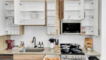 Een koffiezetapparaat/waterkoker, kookgerei, borden en bestek