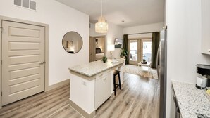 Een moderne keuken met een centraal eiland, inbouwapparatuur en een eetgedeelte met uitzicht.