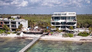A coastal hotel with clear waters, a pier, and modern architecture. - Charming 2-bedroom apartment in lovely Dreams Tulum (Dreams Tulum)