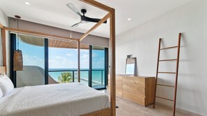 A modern bedroom with a large bed, wooden headboard, a ceiling fan, a wooden dresser, and a ladder. - Charming 2-bedroom apartment in lovely Dreams Tulum (Dreams Tulum)