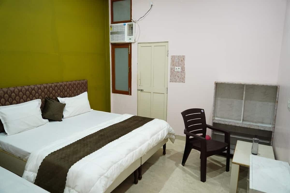 Une chambre à coucher avec un lit, une chaise, une table et une fenêtre.