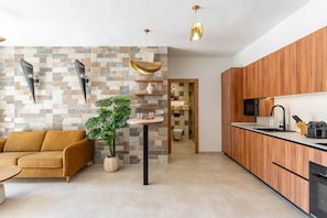 Una cocina moderna con armarios de madera, microondas integrado y un lavamanos.