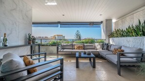 Un espace de vie extérieur moderne comprenant un ensemble de canapés, une table basse et une table à manger.