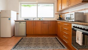 A kitchen with wooden cabinets, a built-in oven, a microwave, and a dishwasher.
