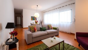 A living room with a sofa, coffee table, and a lamp.