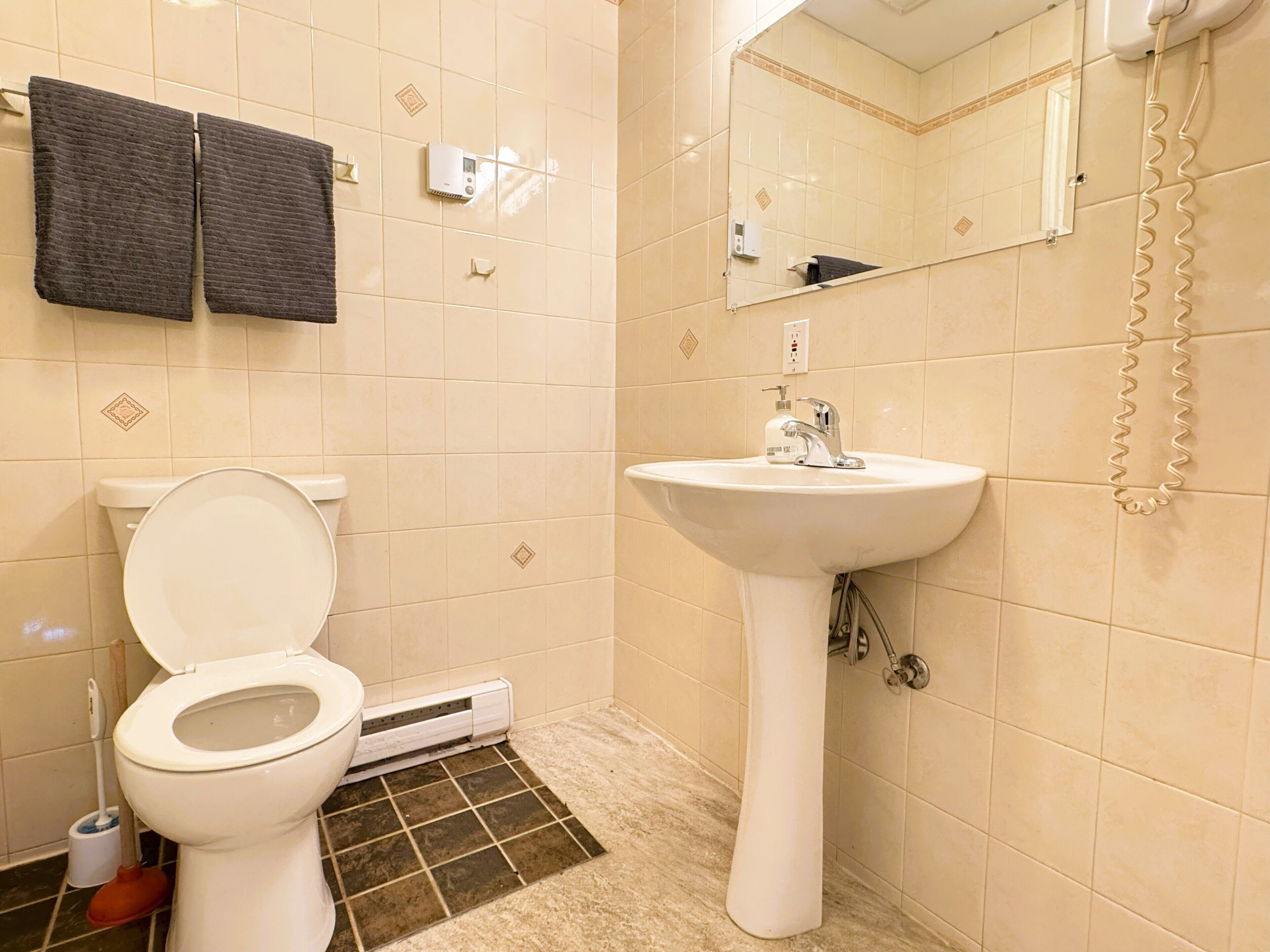 Une salle de bain avec des toilettes, un lavabo et une douche.