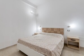 Une chambre à coucher avec un lit, des tables de chevet et une tête de lit.