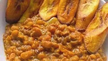 A bowl of lentils with sliced plantains.