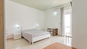 A bedroom with a bed, bedside tables, a desk, and a chair. - Room 'Blu Dea -  2' with Shared Terrace, Wi-Fi and Air Conditioning (Torre Lapillo)