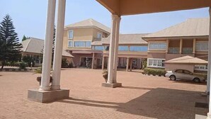 A multi-story building with a covered entrance area and a paved driveway. - Hallydays Hotel and Resort (Makurdi)