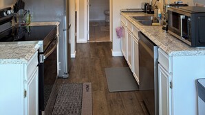 A modern kitchen with white cabinets, stainless steel appliances, and a granite countertop. - Mountain Greenery & Private Sauna w Stunning Pikes Peak Views (Colorado Springs)