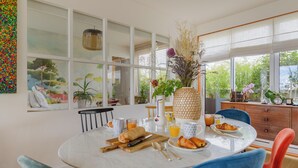 A dining area with a round table, chairs, and a variety of breakfast items. - Paris Rooftop Prestige residence (Paris)