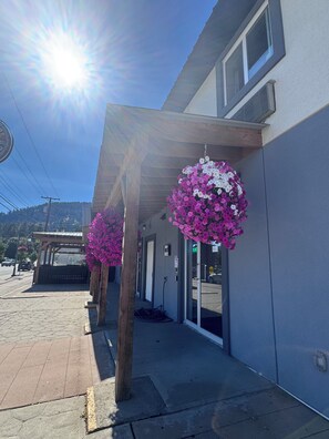 A building with a covered entrance, a parking area, and a clear sky. - Ramshorn Motel (Lumby)