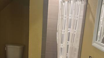 A bathroom with a toilet, a sink, and a shower curtain.