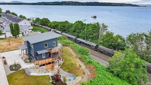 A house with a large deck and a view of a lake. - Cedarcrest House (Blaine)