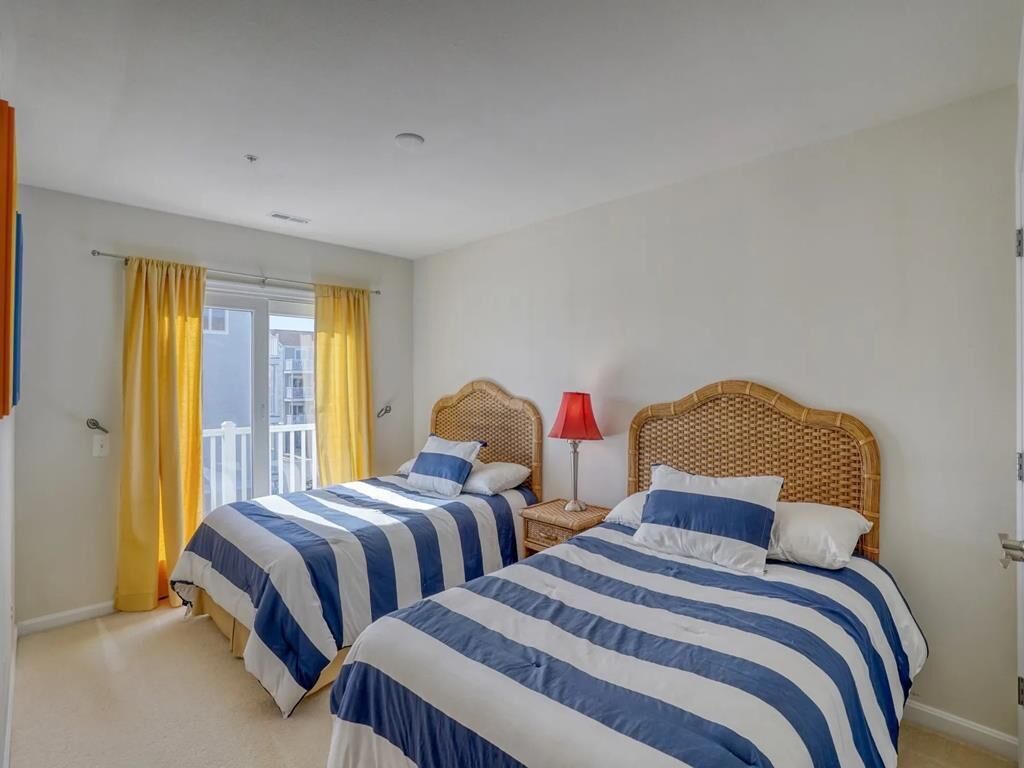 Un dormitorio con dos camas, un balcón y una lámpara roja.