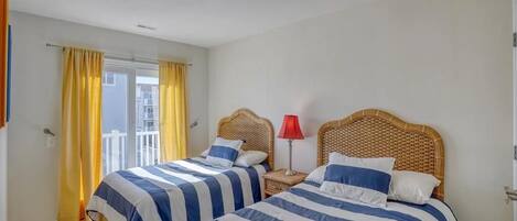 Un dormitorio con dos camas, un balcón y una lámpara roja.