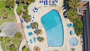 An aerial view of a swimming pool area with lounge chairs and a small circular pool. - Corner Beachfront Condo: Stunning 270° Views. Wraparound Balcony. Heated Pool (Corpus Christi)