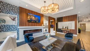 Een moderne woonkamer met een open haard, comfortabele zitplaatsen en een groot televisiescherm.